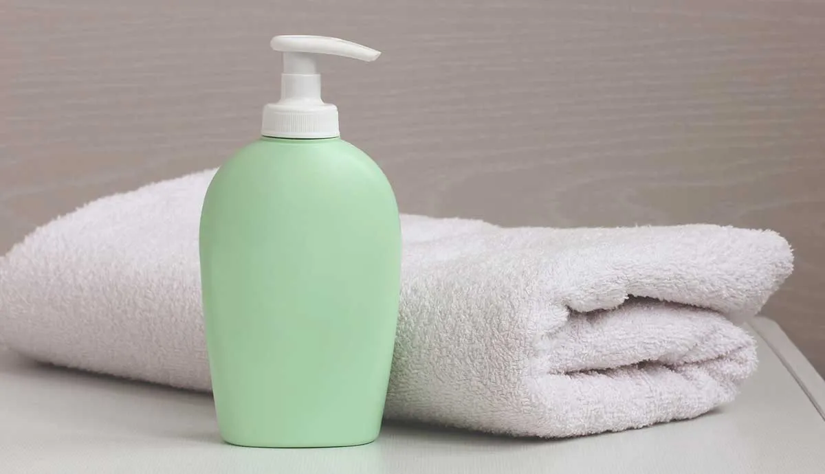 Lotion bottle on table with bath towel